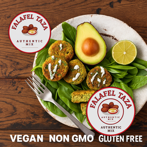 Platter of falafel with avocado, lime, and greens on a wooden surface with Falafel Taza Mix Special 